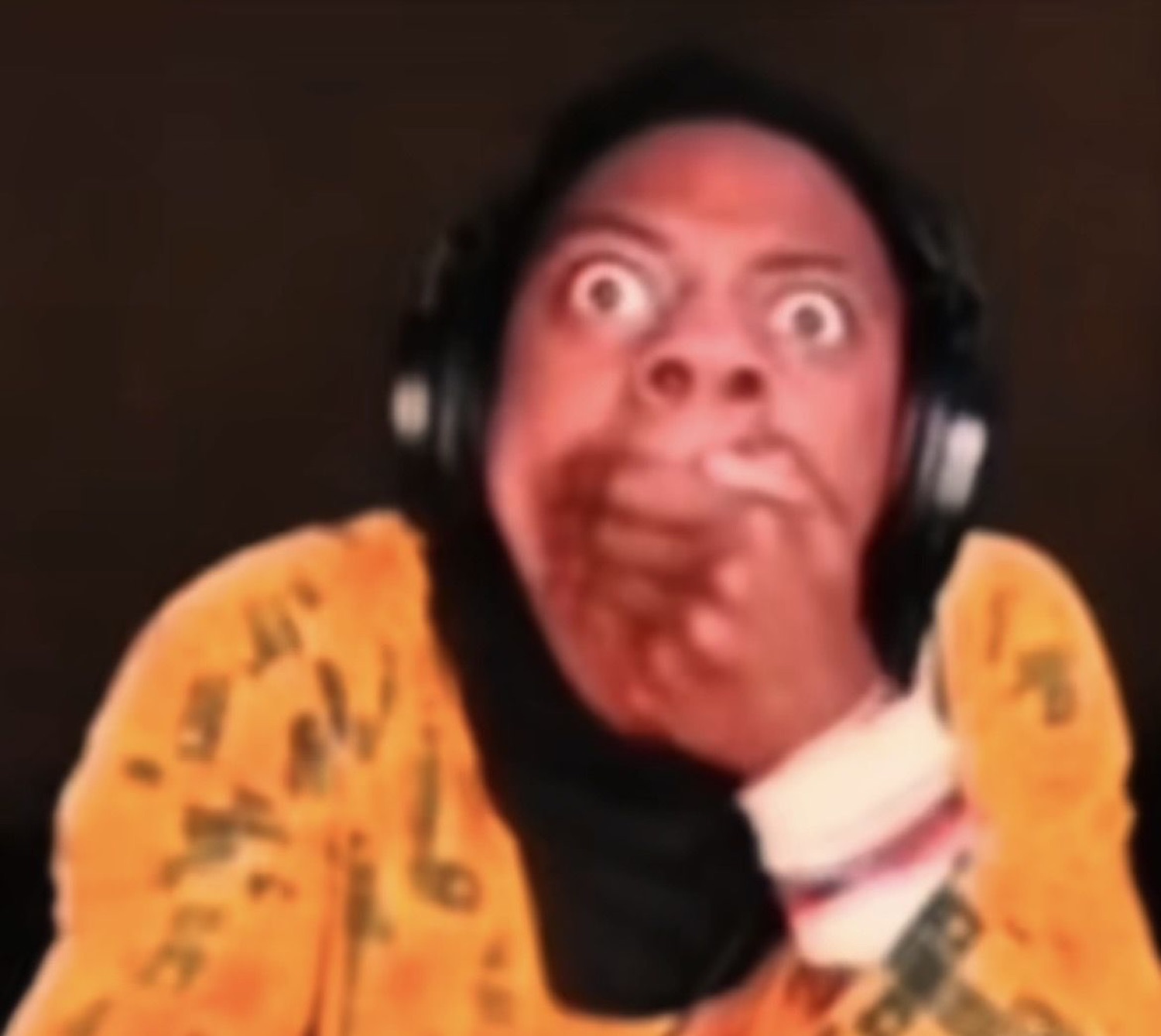 Person with headphones and huge wide eyes, hand over mouth in disbelief