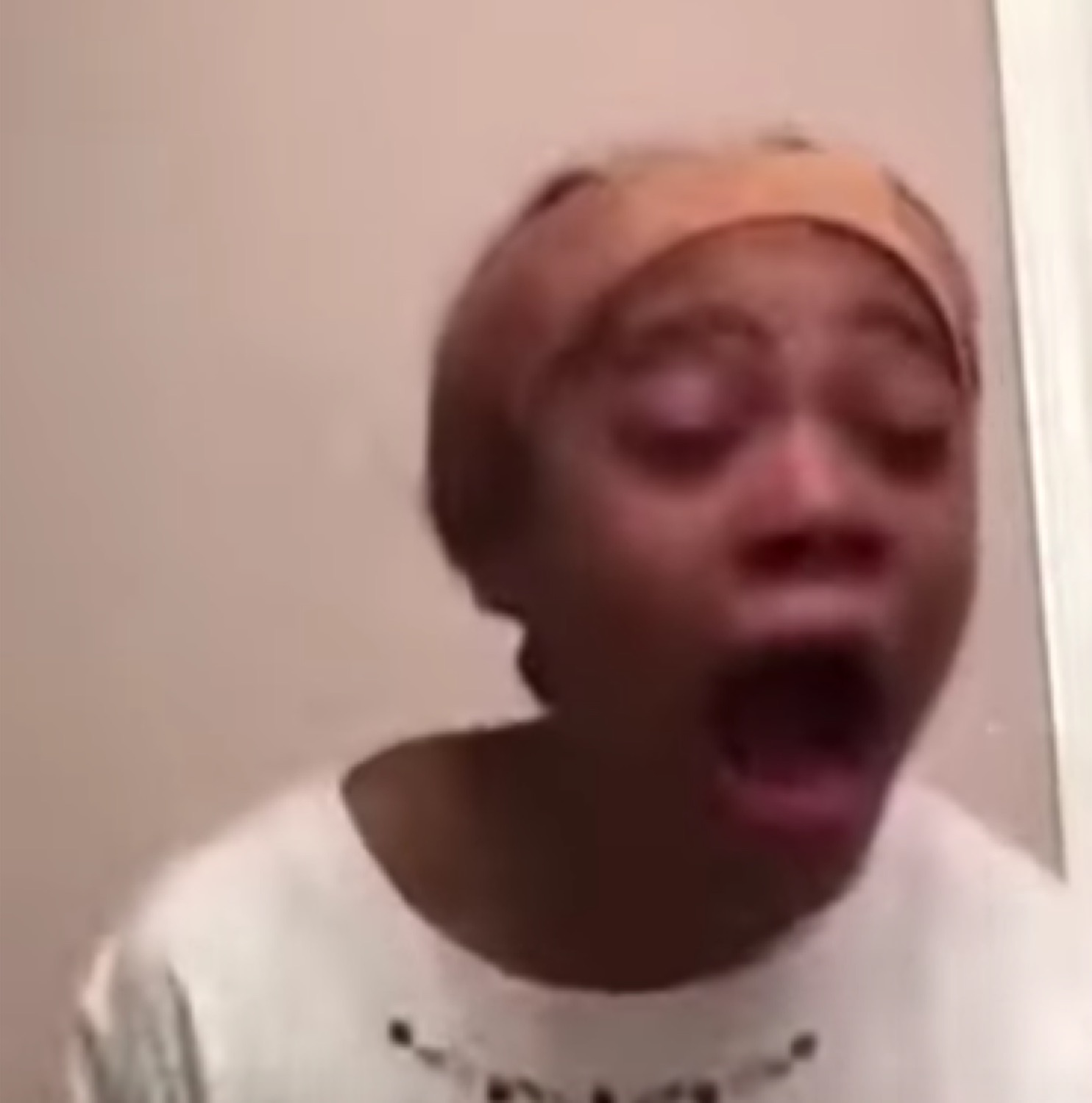 Girl in a headband screaming with her mouth wide open