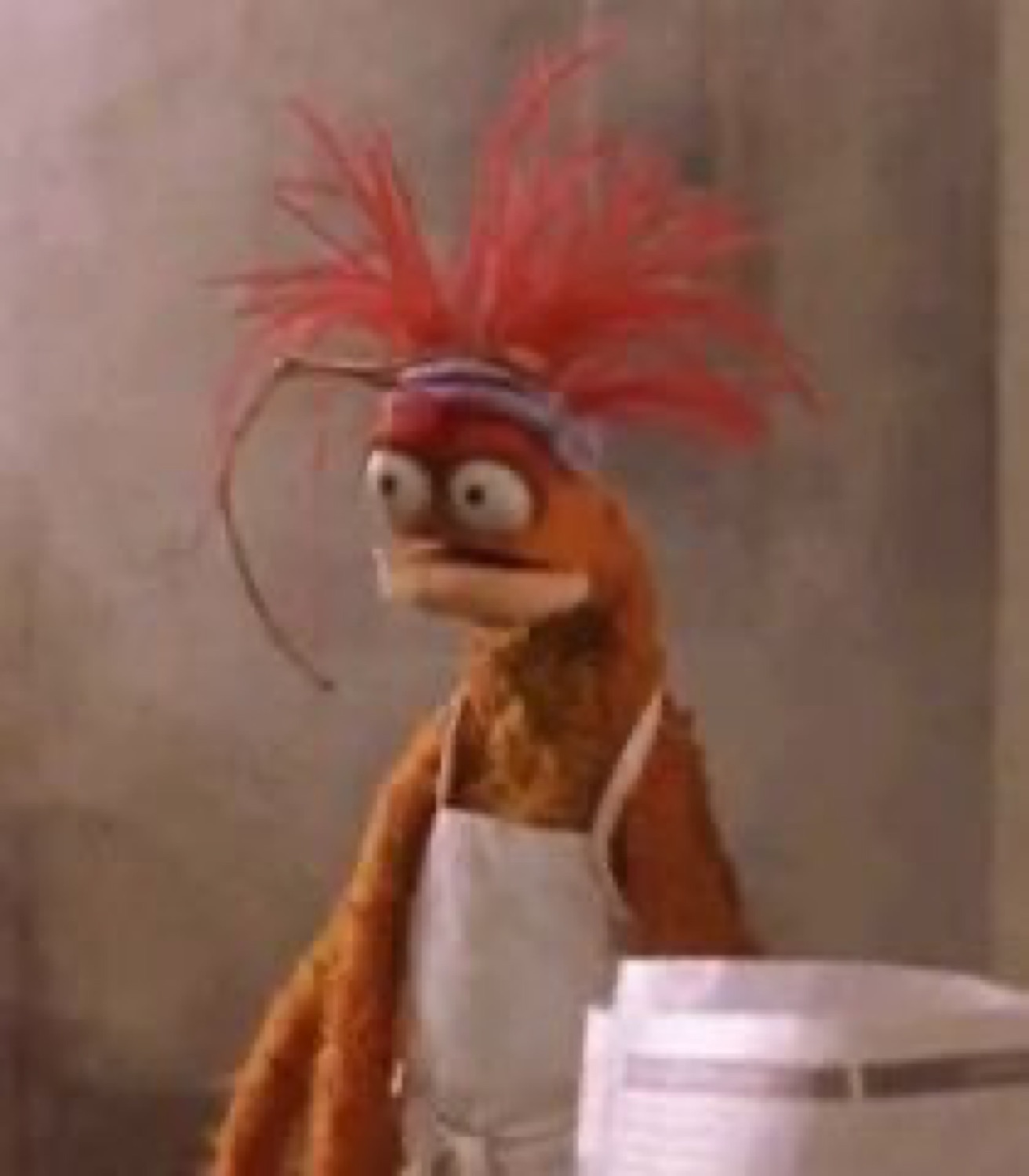 Pepe the King Prawn in an apron with bug eyes locked on the camera