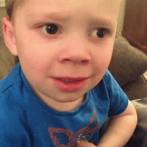Toddler in a blue shirt pulling a puzzled face