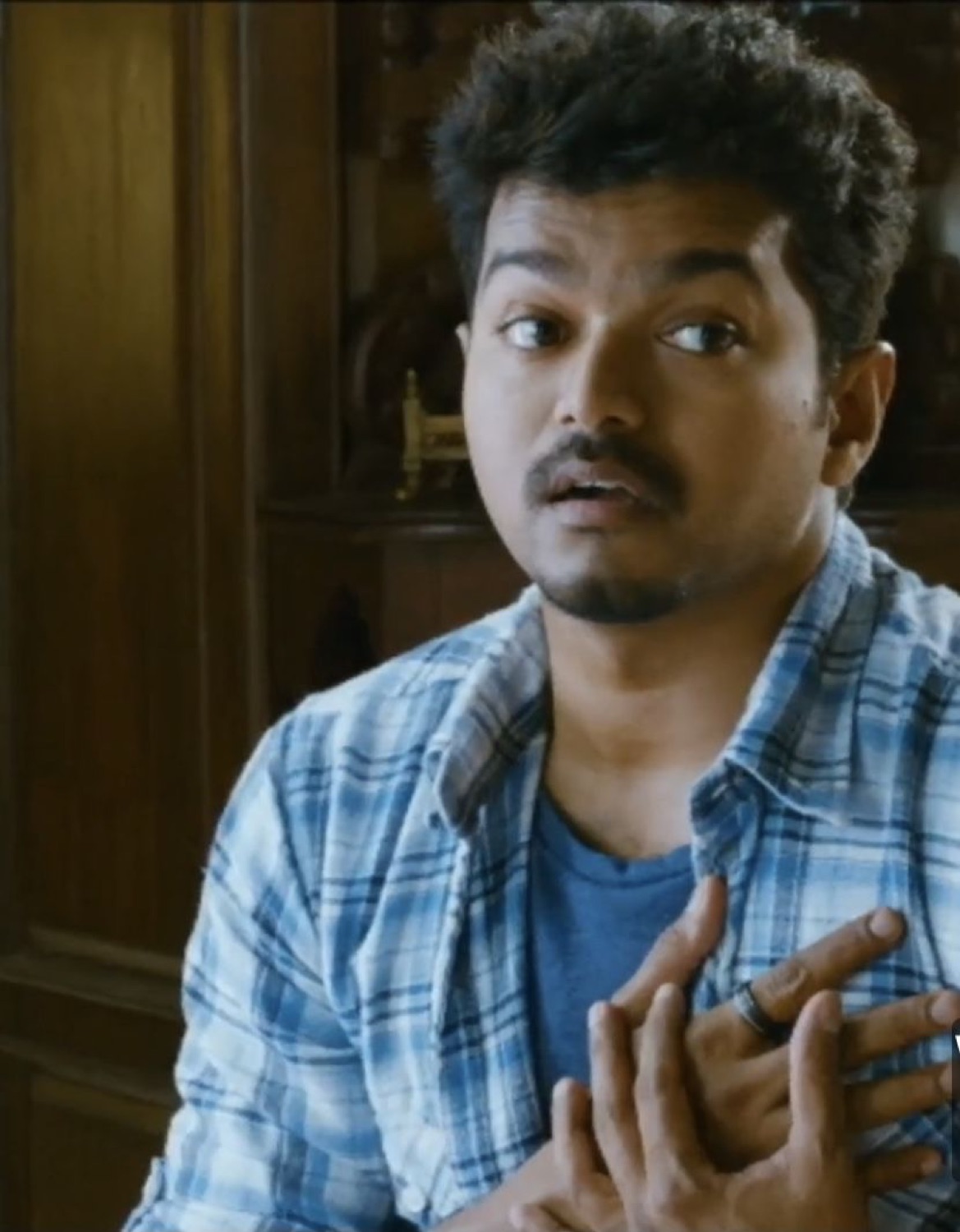 Vijay with his hand on his chest looking taken aback