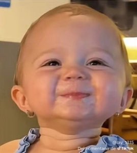 Adorable baby with chubby cheeks giving the smuggest little grin to camera