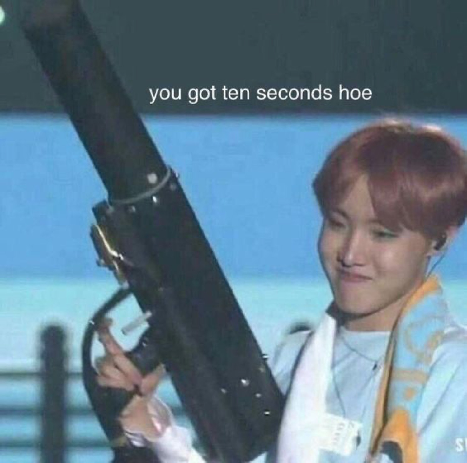 K-pop performer holding a large prop cannon captioned 'you got ten seconds hoe'