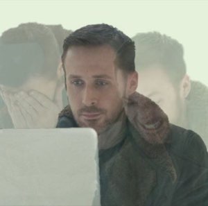 Man staring blankly at a screen with faint ghostly overlaid faces around him