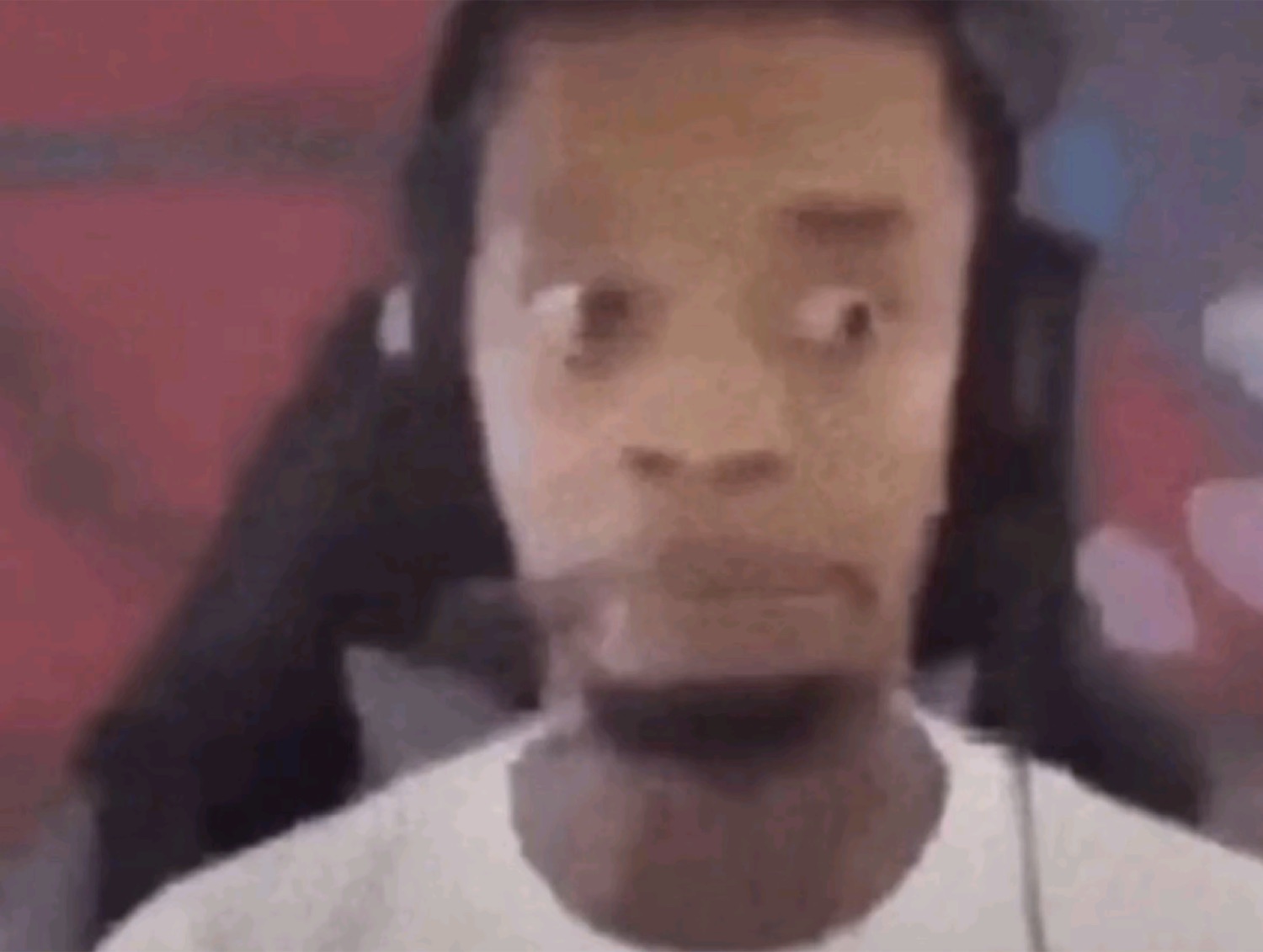 Gamer in a white tee with wide, unsettling eyes staring straight into the camera