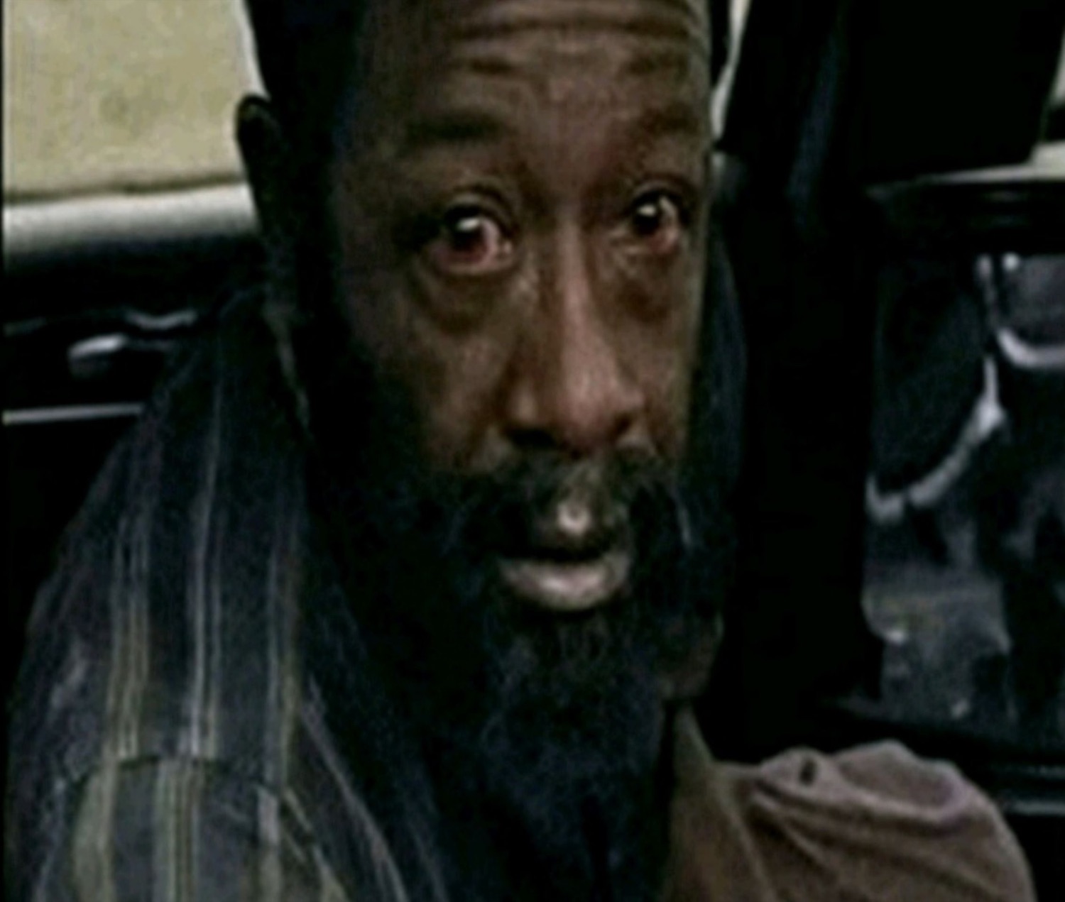 Older man in a car with wild wide eyes looking terrified and completely off-guard