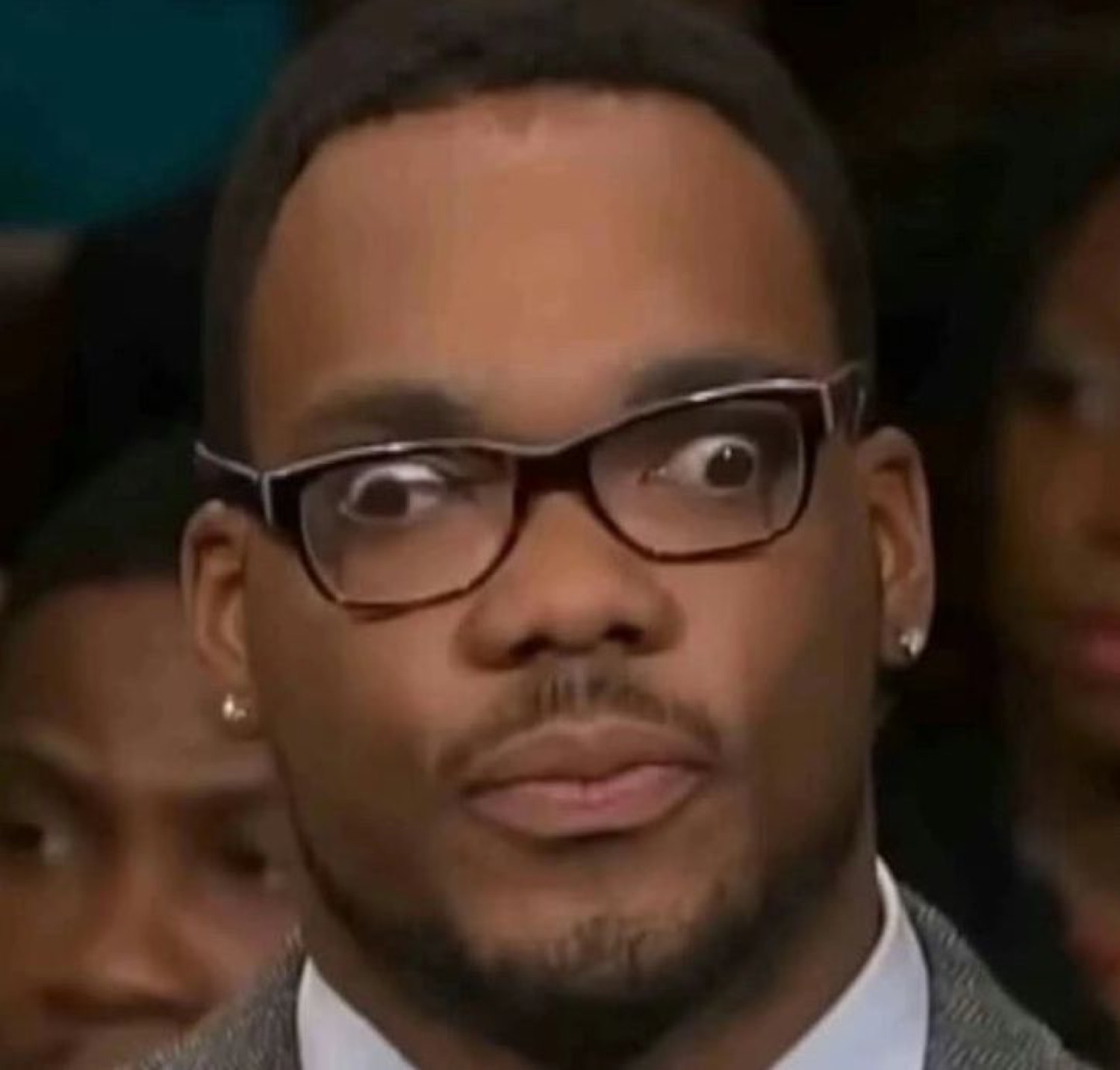 Man in glasses cutting his eyes to the side with a wary, judgmental side-eye