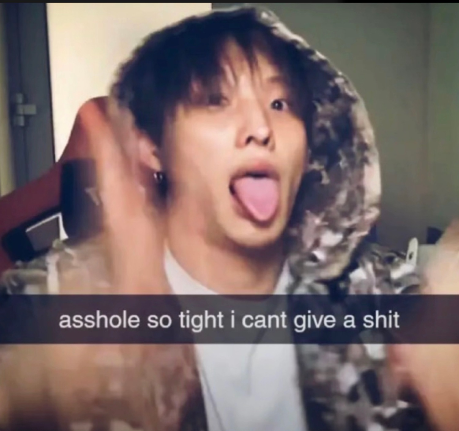 Young man sticking tongue out in a hoodie, captioned 'asshole so tight i cant give a shit'