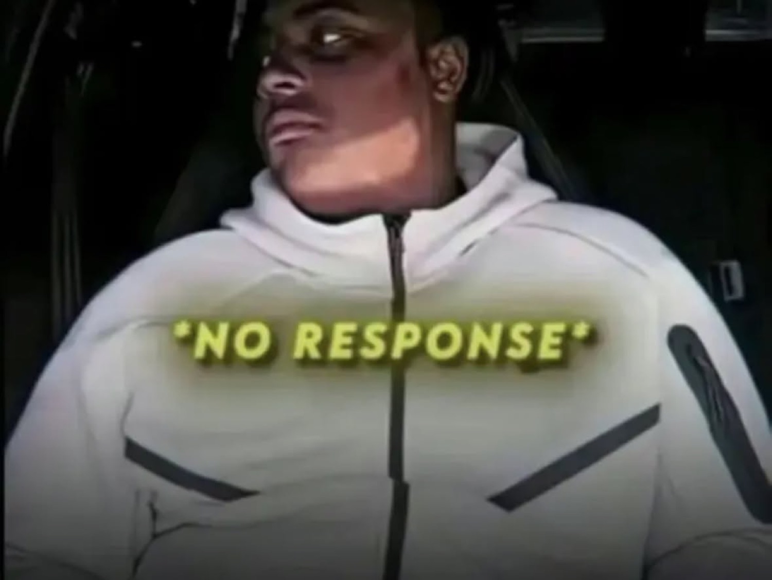 Guy in a white hoodie in a dark car, stone-faced, with '*NO RESPONSE*' text overlay