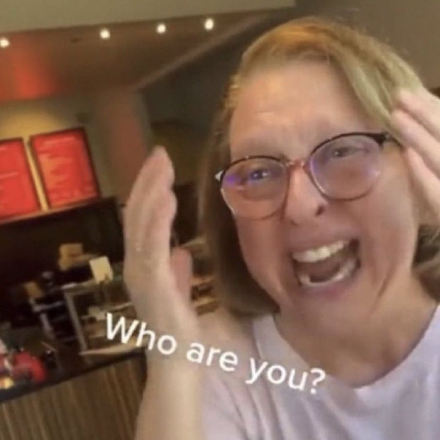 Woman laughing with hands up: 'Who are you?'