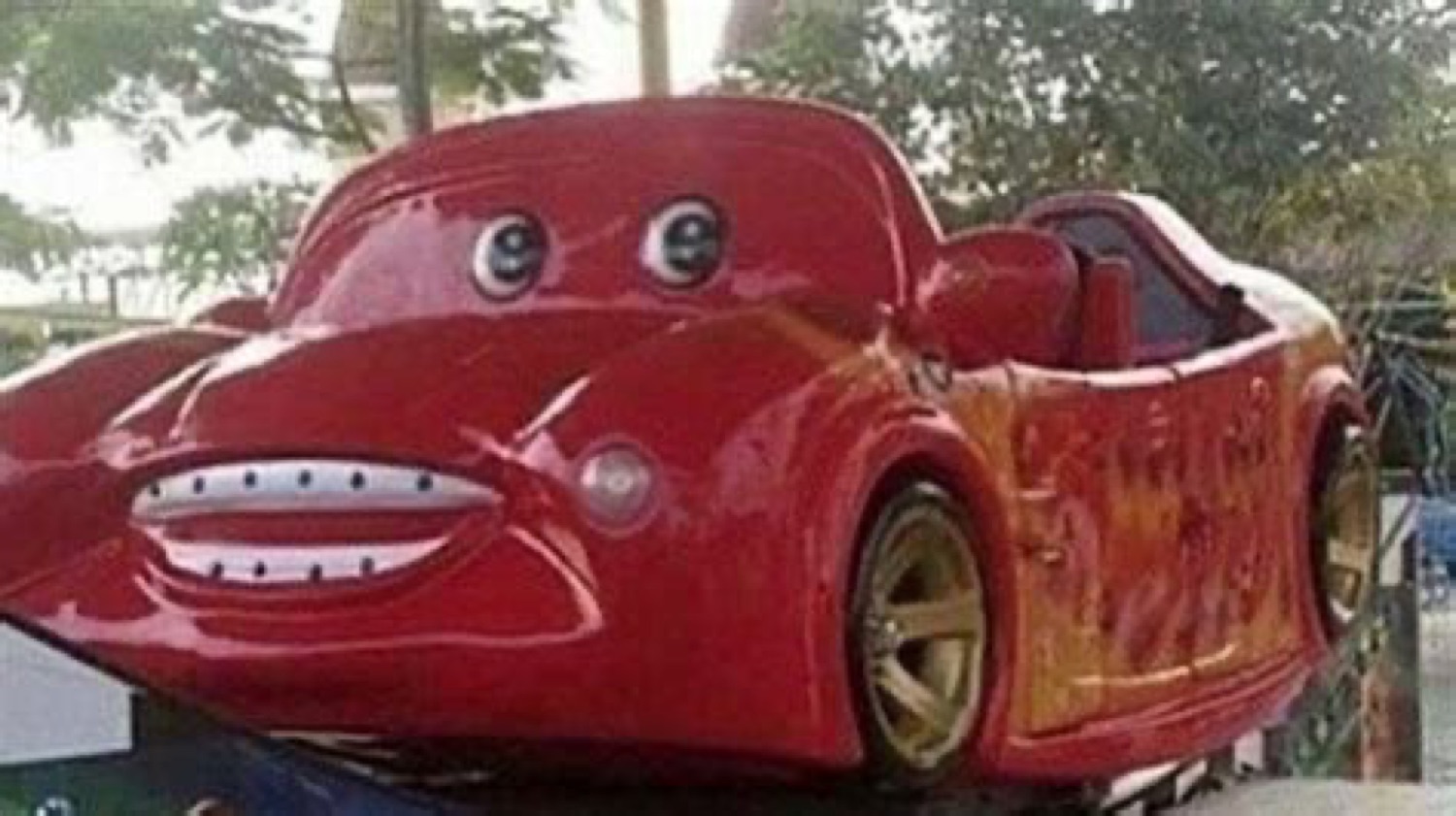 Real red car with a McQueen-style face and a goofy grin
