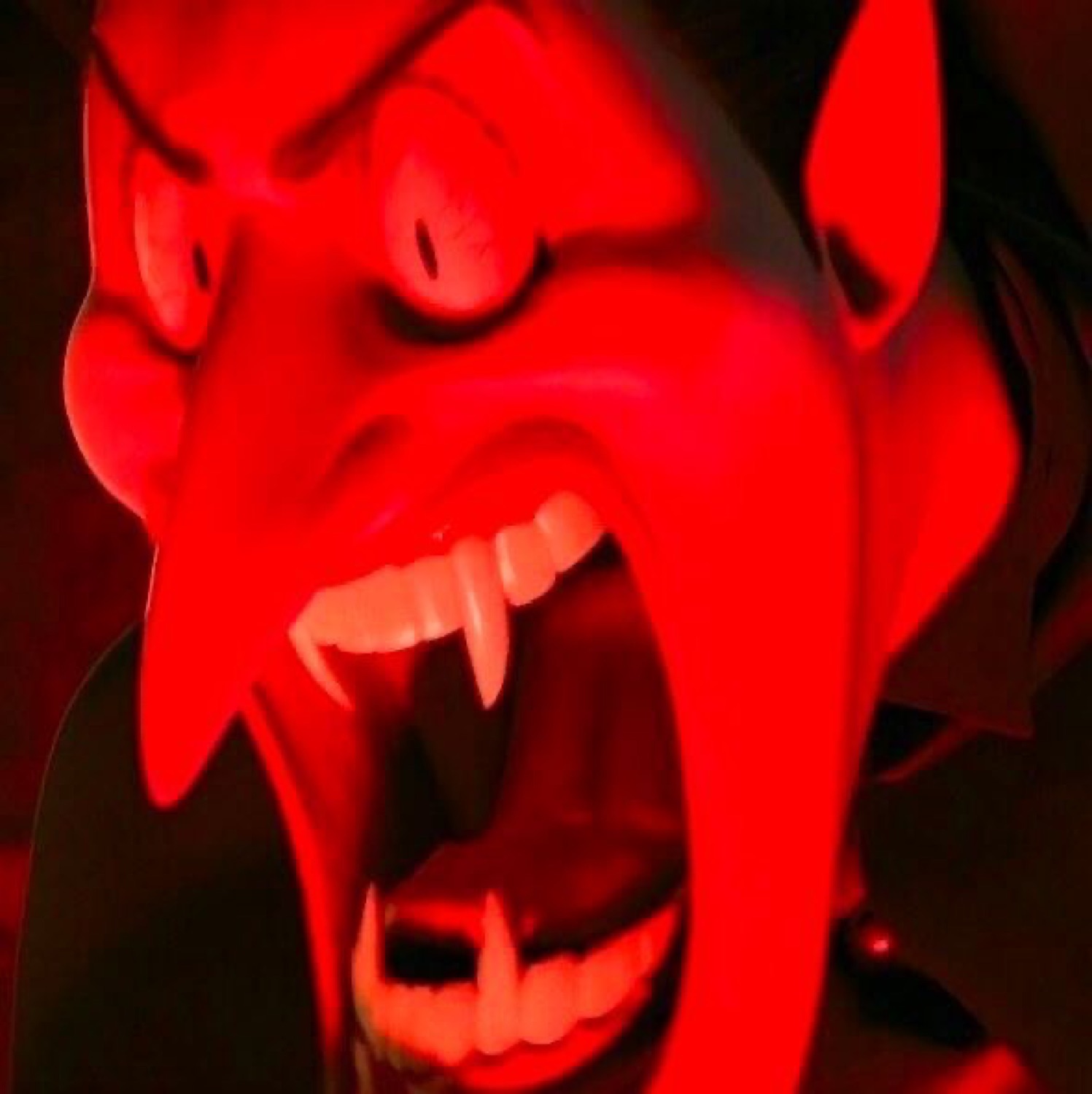 Red-lit Dracula screaming with fangs bared