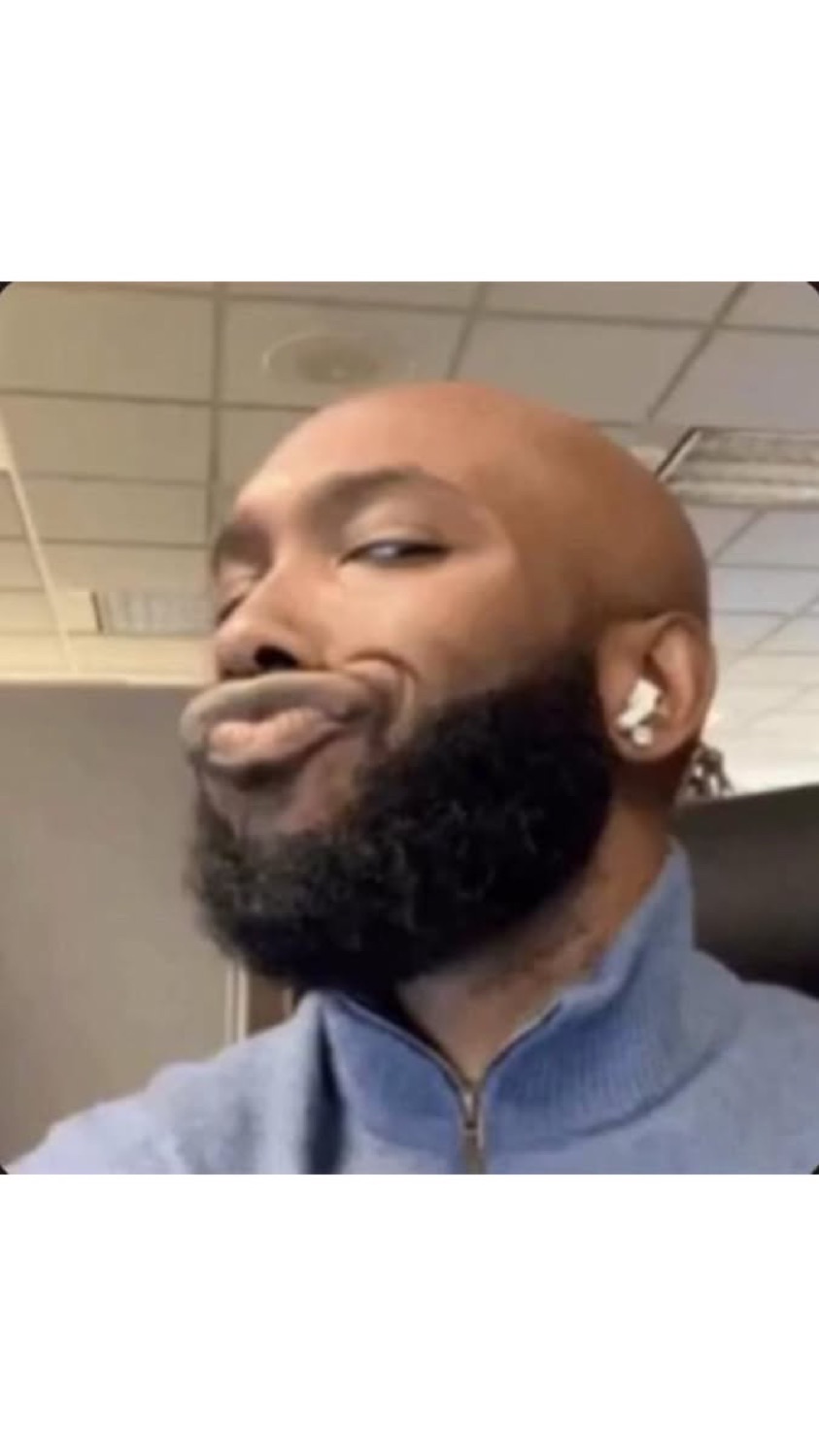 Bearded man pursing his lips in a smug side glance
