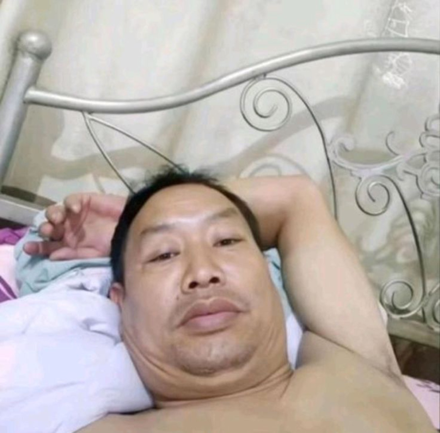 Man lying in bed with an awkward, unsure look