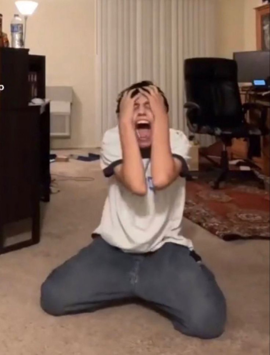 Guy on his knees clutching his head and screaming