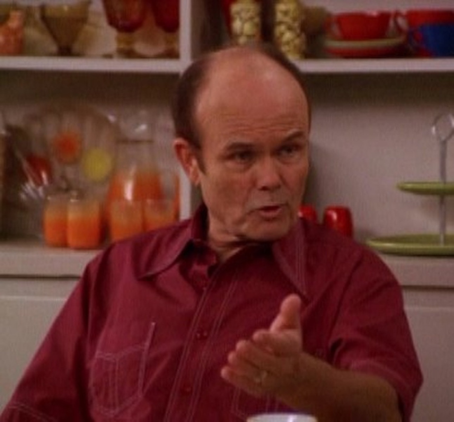 Red Forman gesturing with a flat, irritated expression while making a point