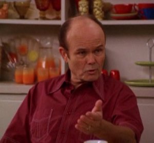 Red Forman gesturing with a flat, irritated expression while making a point