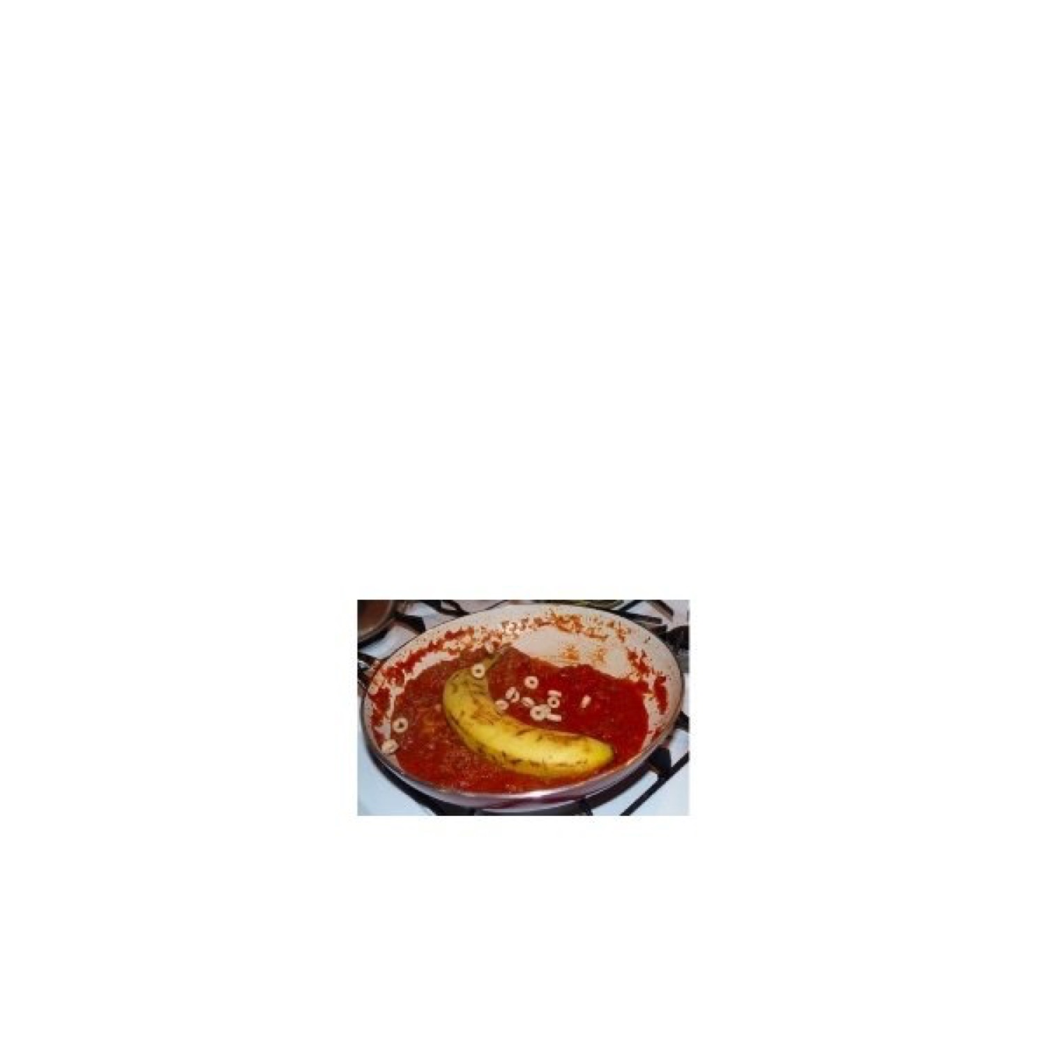 A banana sitting in a pan of tomato sauce with cereal hoops — deeply unhinged meal