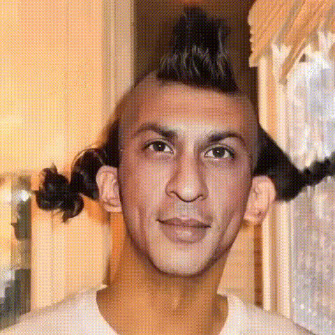 Man with a mohawk and braided pigtails staring at the camera
