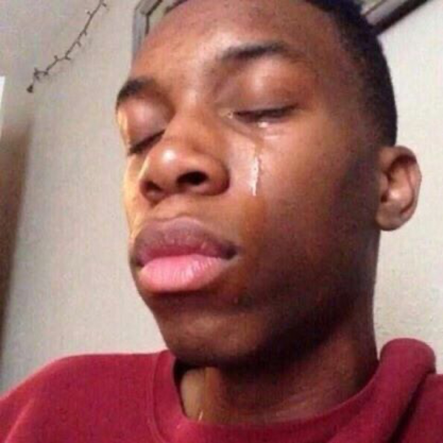 Young guy with eyes shut and a single tear running down his cheek