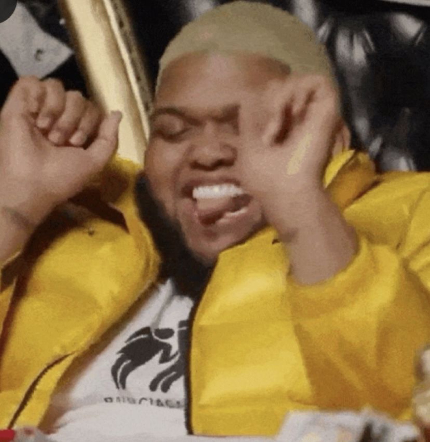 Guy in a yellow jacket clenching his fist and screaming with pure hype
