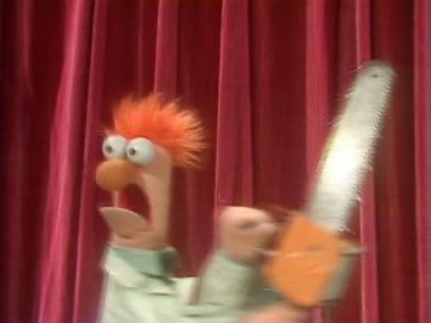 Beaker from The Muppets screaming and holding a chainsaw in a panic