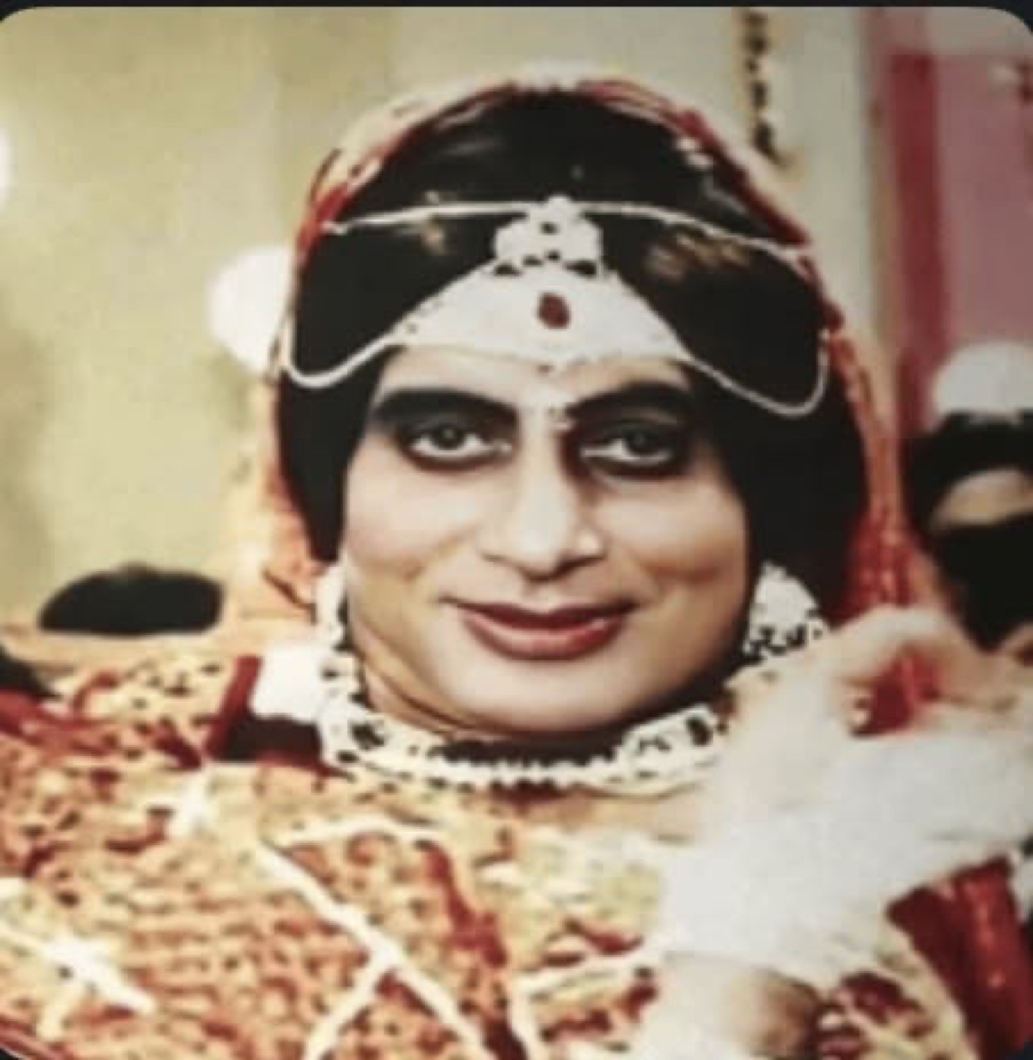 Amitabh Bachchan in bridal makeup with a coy sideways smile