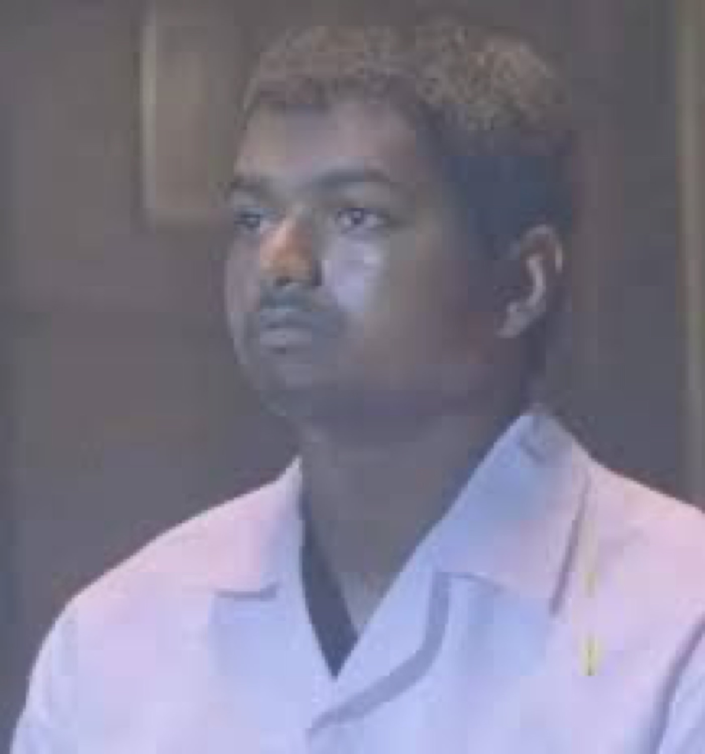 Young Vijay staring off with a blank expression