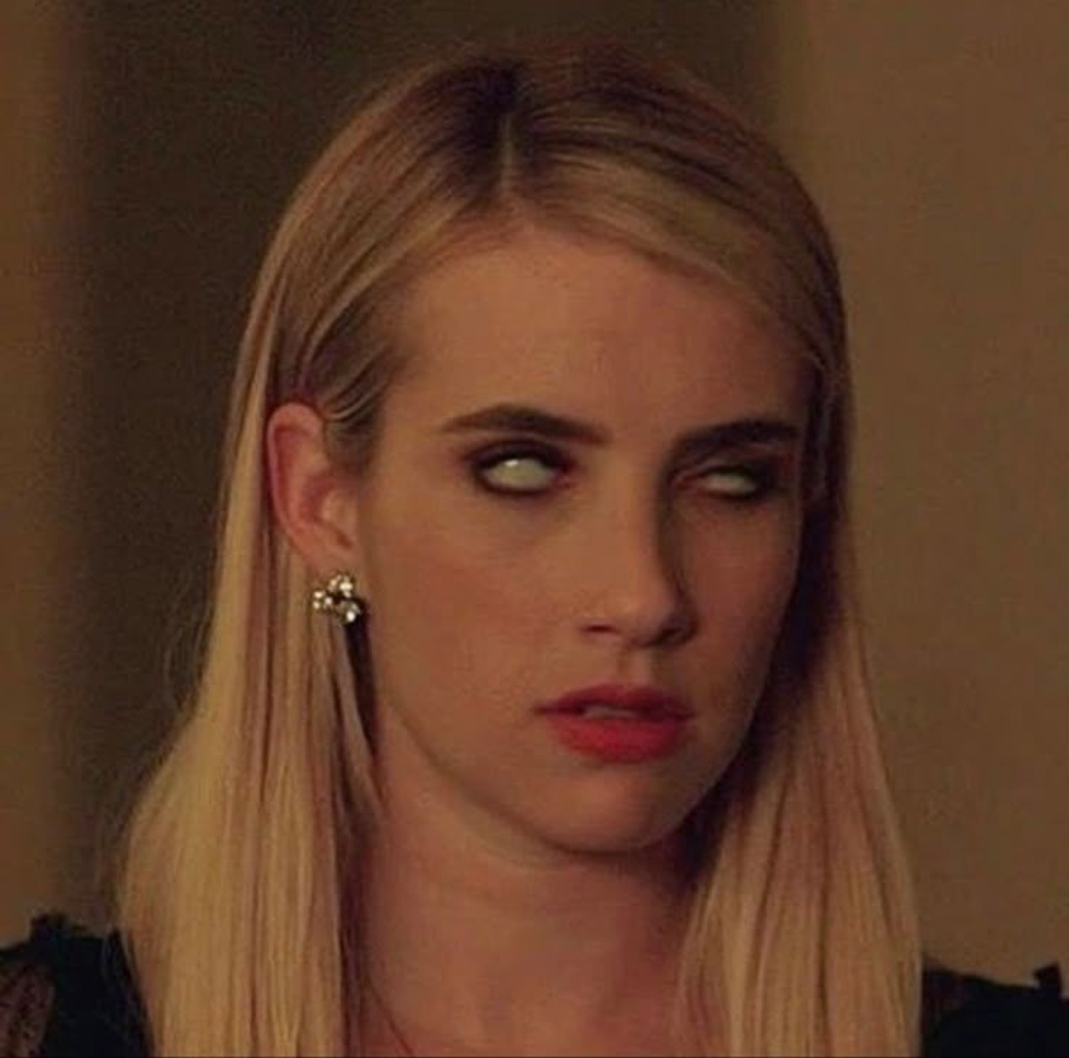 Blonde woman rolling her eyes back dramatically until only the whites show