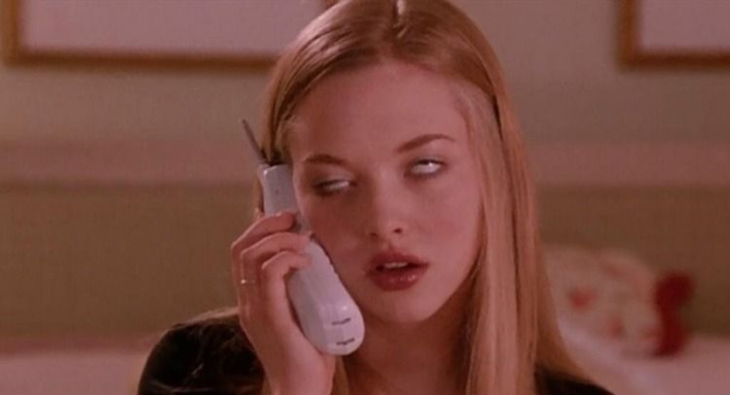 Blonde girl on a cordless phone rolling her eyes back in boredom