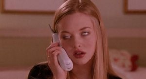 Blonde girl on a cordless phone rolling her eyes back in boredom