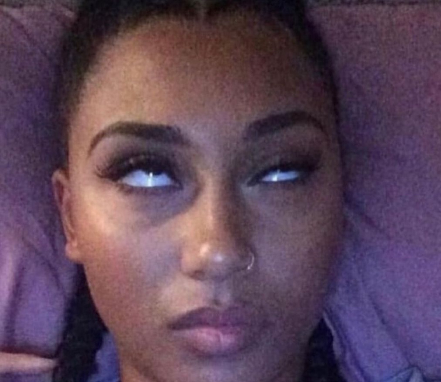 Woman lying back and rolling her eyes up with a completely unbothered expression