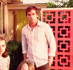 Michael C. Hall as Dexter shrugging in front of a pink wall