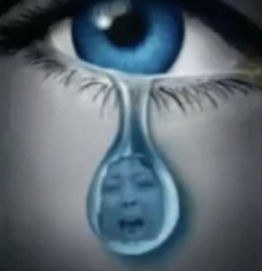 A tiny screaming, crying face trapped inside a single teardrop falling from a blue eye