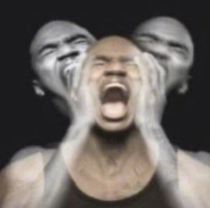 Motion-blurred portrait of a man screaming and clutching his head in anguish