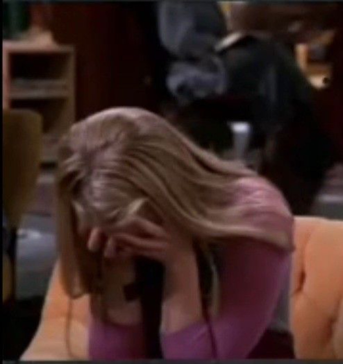 Woman in pink slumped over with her face buried in her hand, clearly defeated