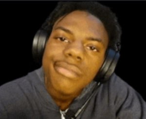 Young man in headphones smirking smugly at the camera in a dark room