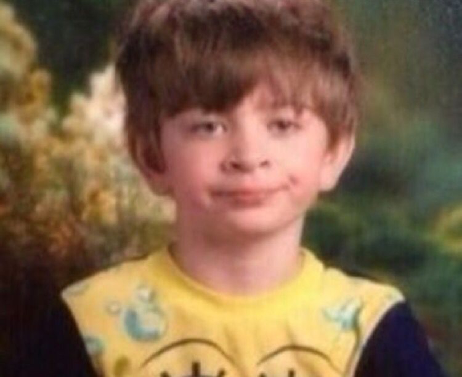 Kid's school photo with a chocolate-smeared mouth and a slightly smug little smile
