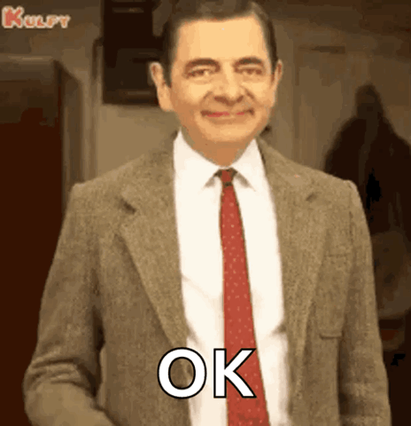 Mr. Bean in a suit giving a thumbs up, "OK"