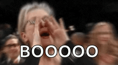 Older woman in a crowd cupping her hands and booing loudly