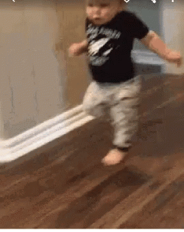 Toddler running away down a hallway with toilet paper