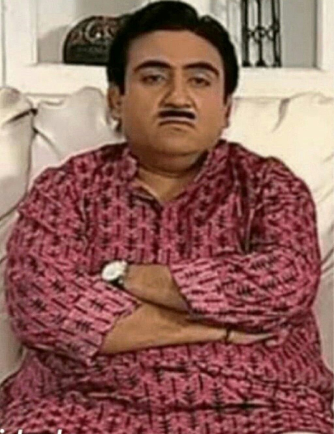 Jethalal sitting with arms crossed and a sulky pout