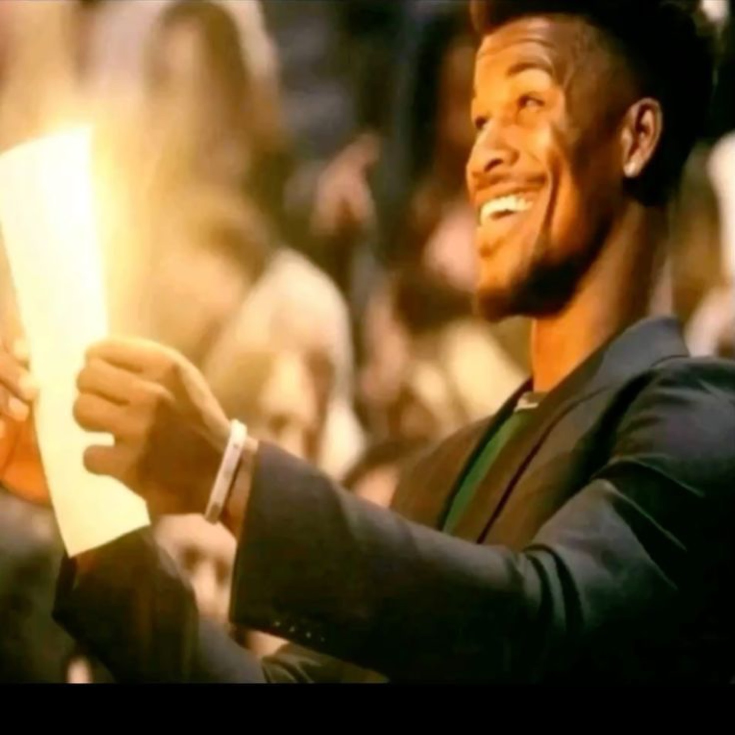 Man reading a glowing piece of paper with a huge joyful smile