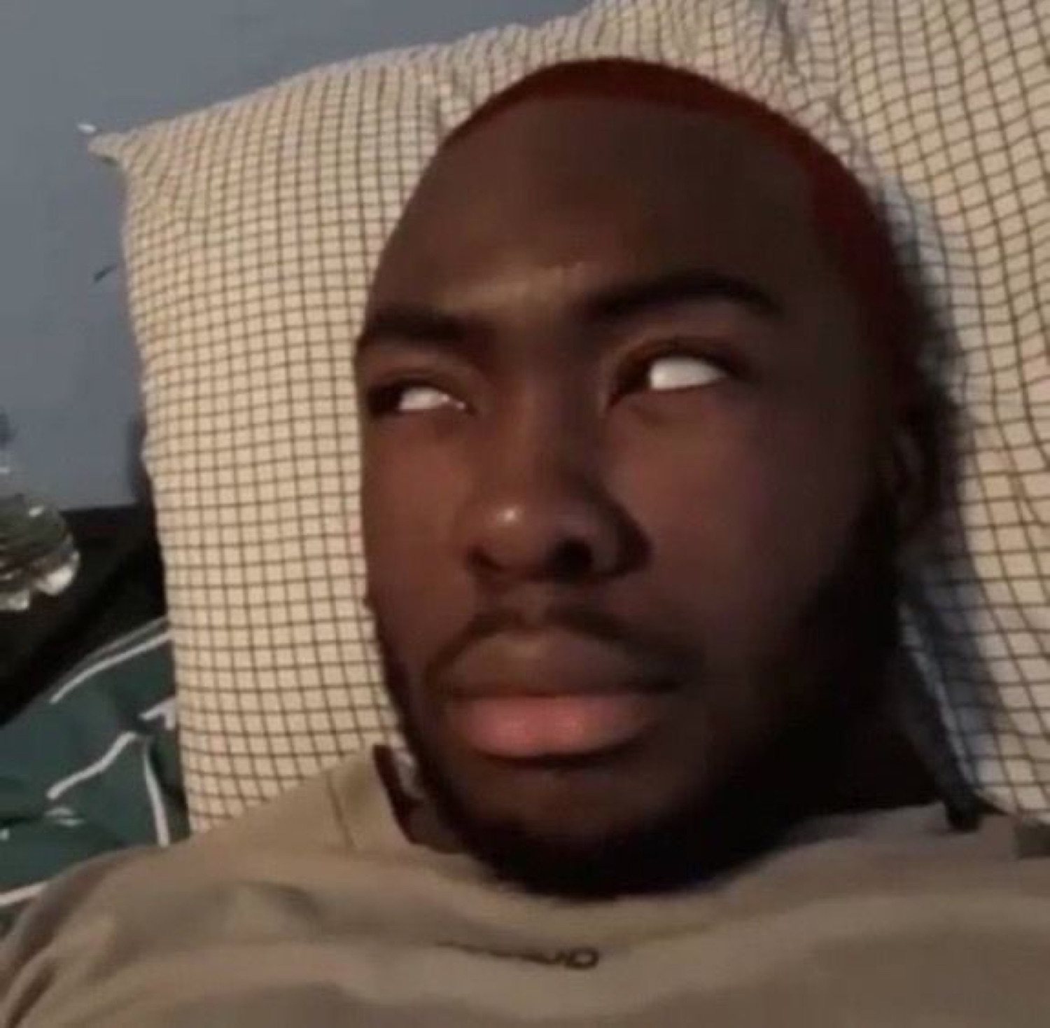 Man lying on a pillow rolling his eyes back with a totally over-it look