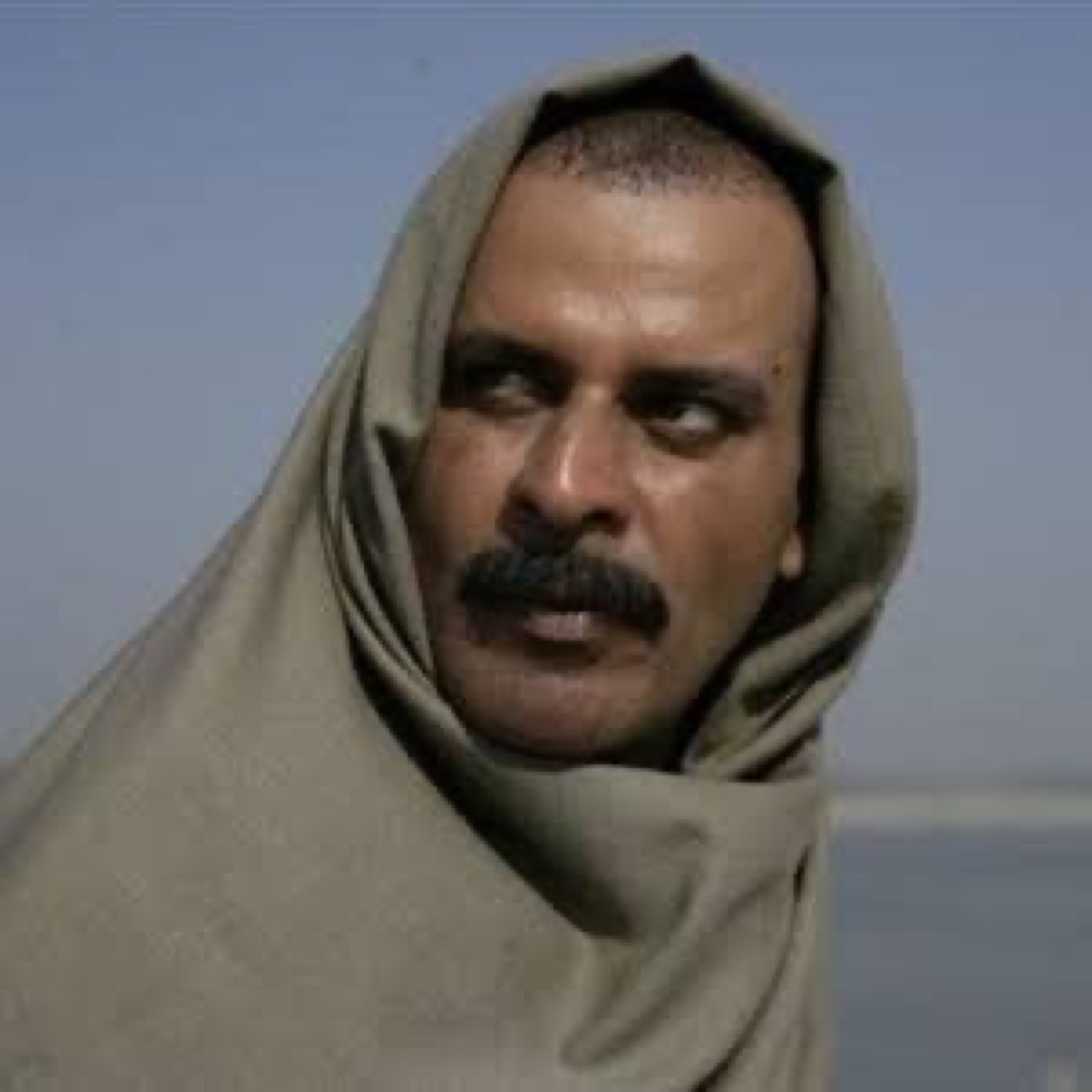 Manoj Bajpayee wrapped in a shawl giving a slow suspicious side-eye