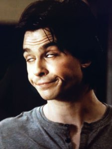 Man giving a cross-eyed, forced, awkwardly smug grin