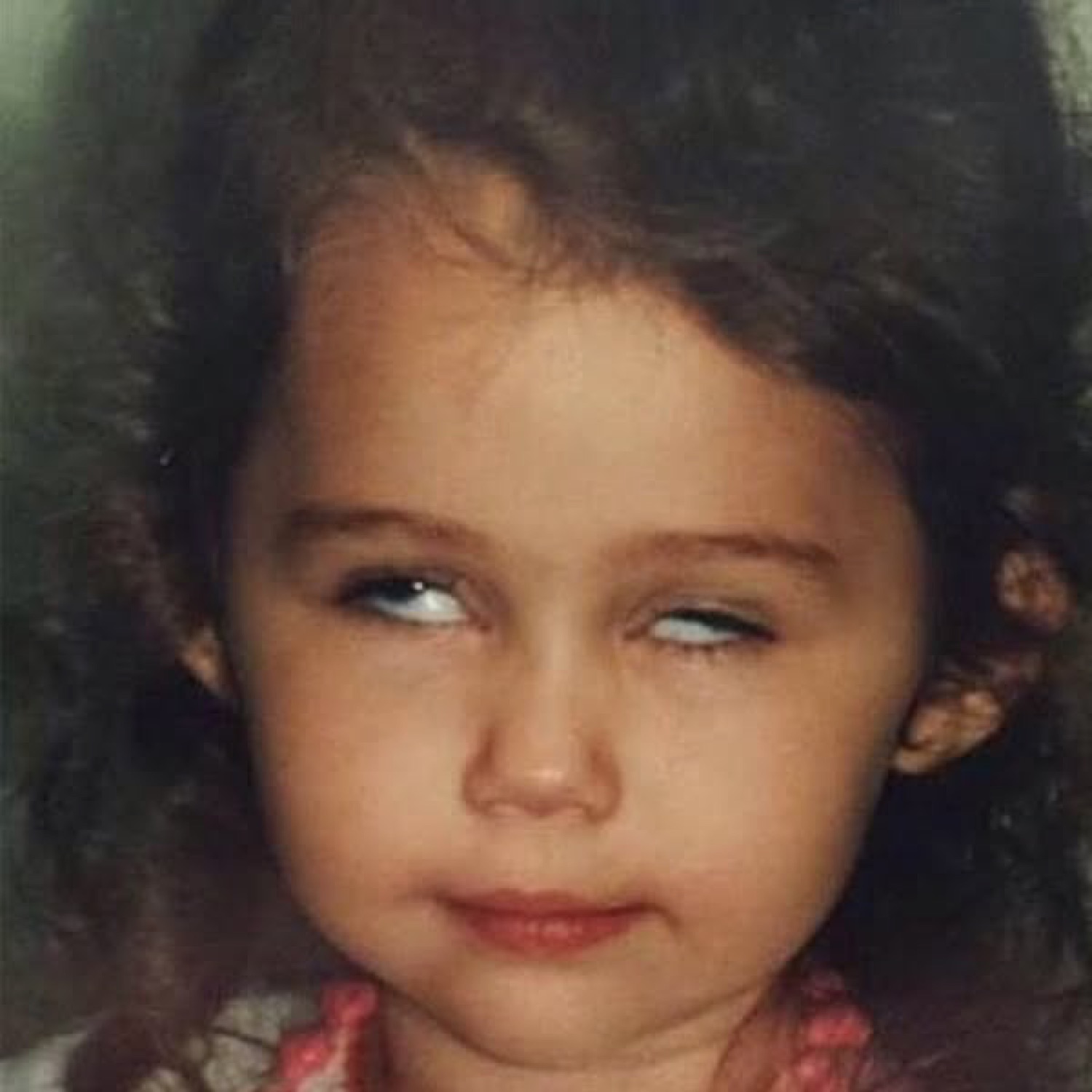 Little girl rolling her eyes to the side with a smug, suspicious smirk