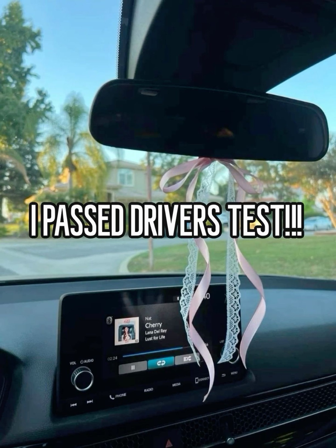 Car dashboard with ribbons: 'I PASSED DRIVERS TEST!!!'