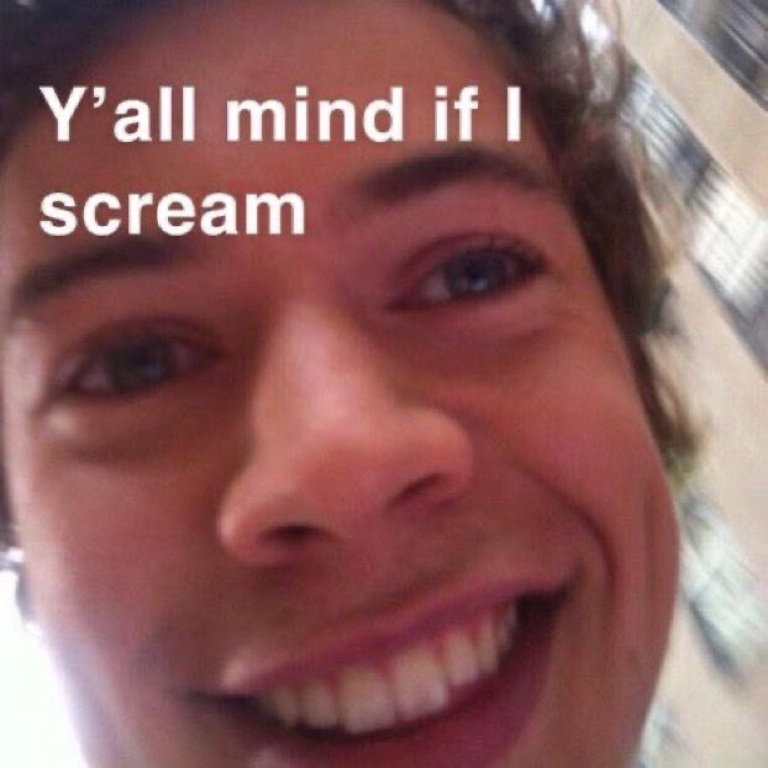 Grinning guy in an extreme close-up selfie, captioned 'Y'all mind if I scream'