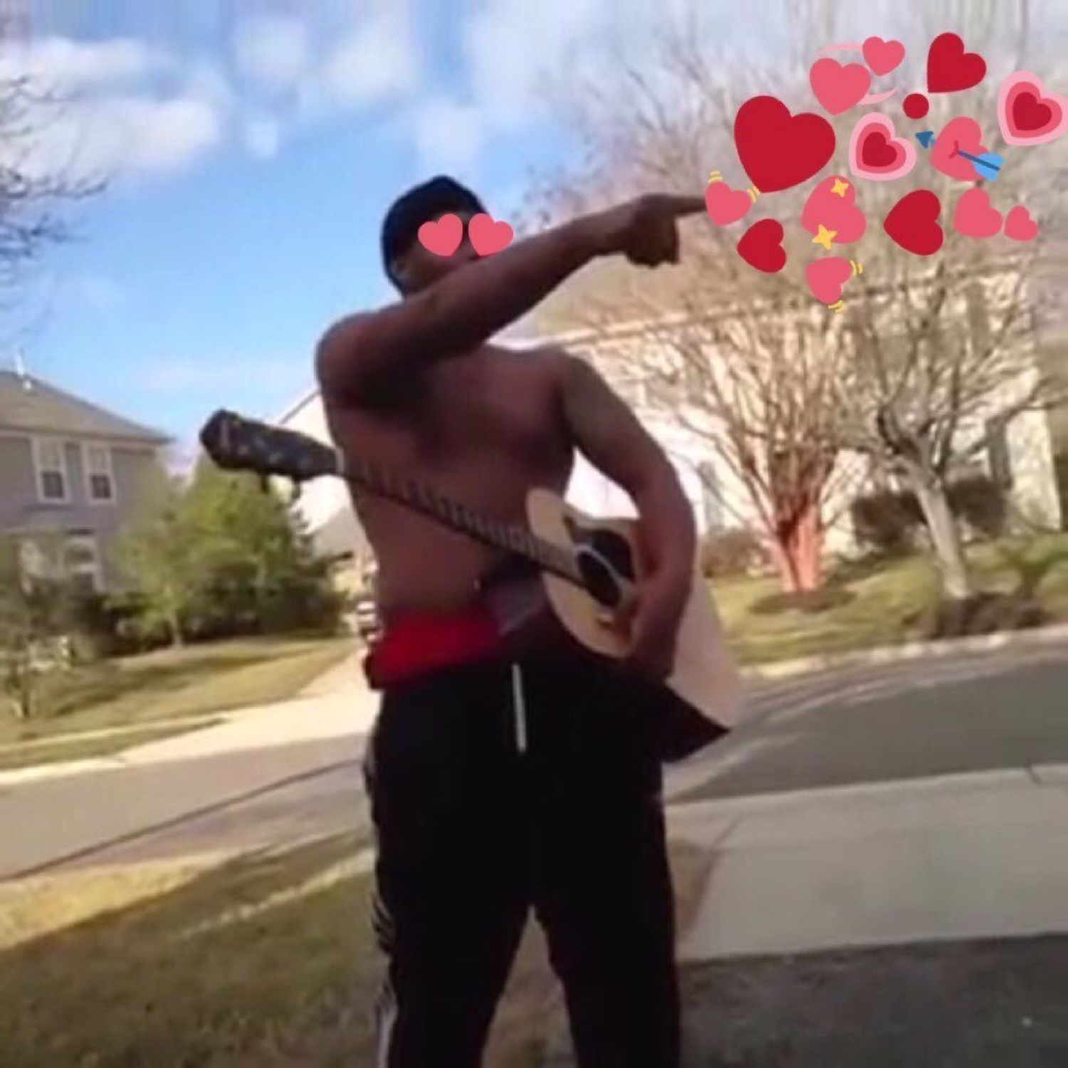 Shirtless guy with a guitar on his back pointing dramatically, covered in heart emojis
